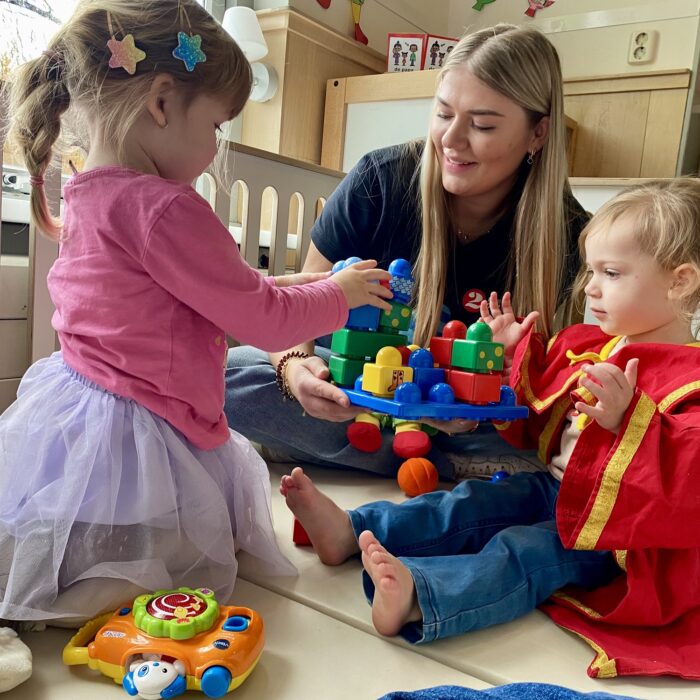 Twee peuters spelen met hun speelgoed samen met een pedagogisch medewerker bij VE 2Ballonnen in Monster.