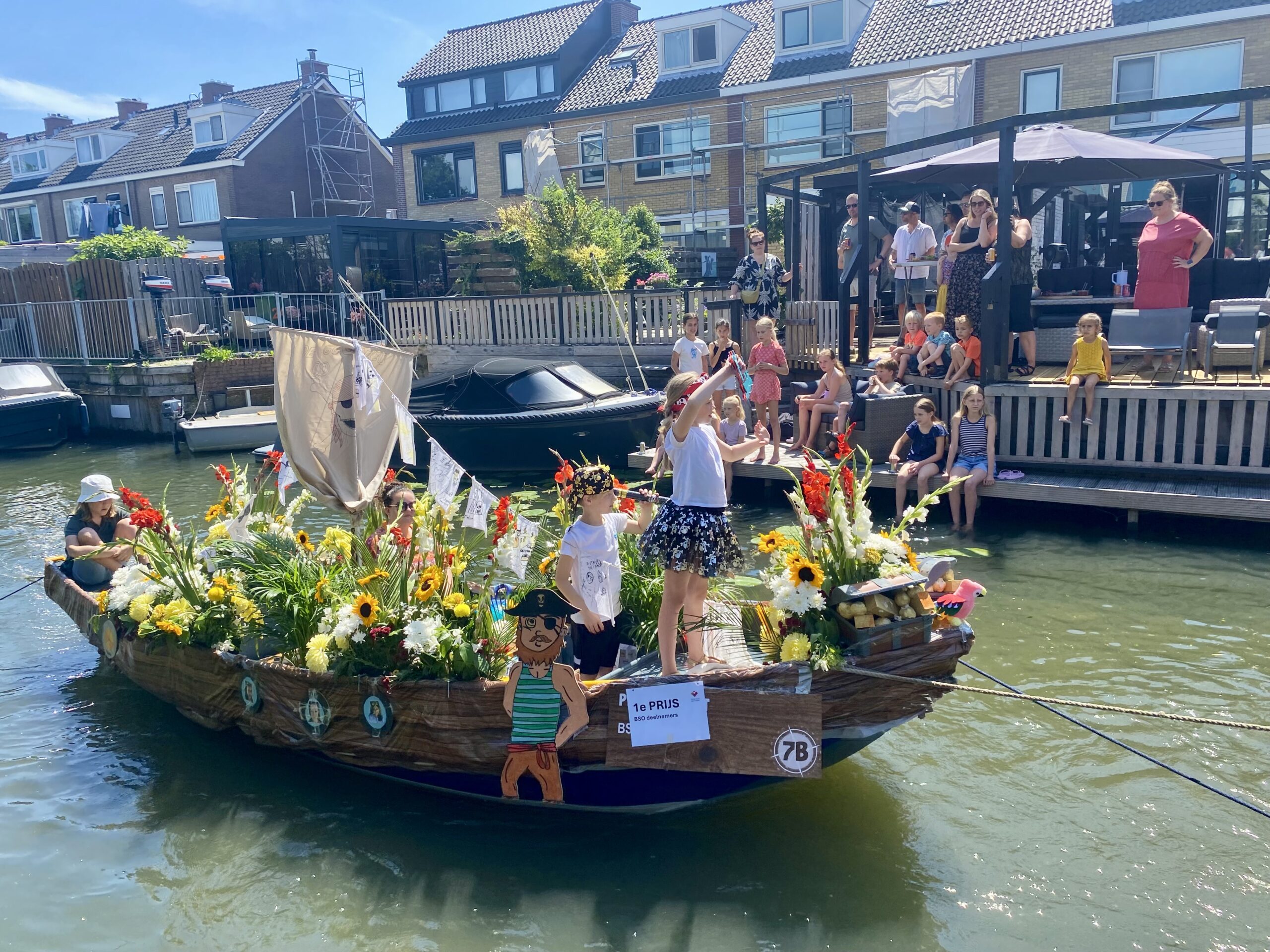 De piratenboot van BSO 2Flamingo's in Naaldwijk vaart door de wateren van hun eigen dorp Naaldwijk. Twee piraten zie je aan boord op zoek naar de schat.