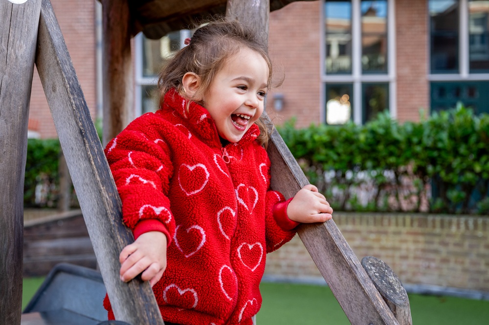 meisje gaat van de glijbaan bij kinderdagverblijf 2ooievaars in statenkwartier den haag kinderopvang 2samen