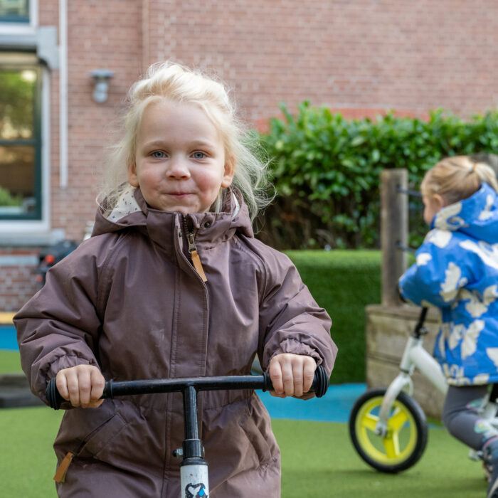 meisjes fietsen bij speelplein kinderdagverblijf 2ooievaars in statenkwartier den haag kinderopvang 2samen